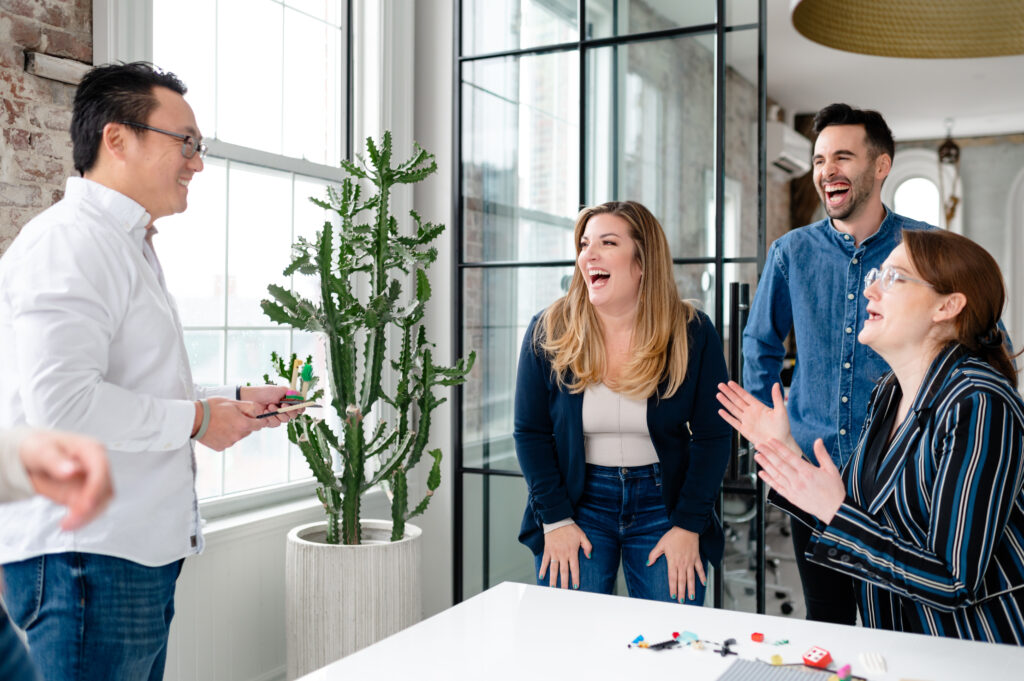 Group of diverse people standing around a table laughing