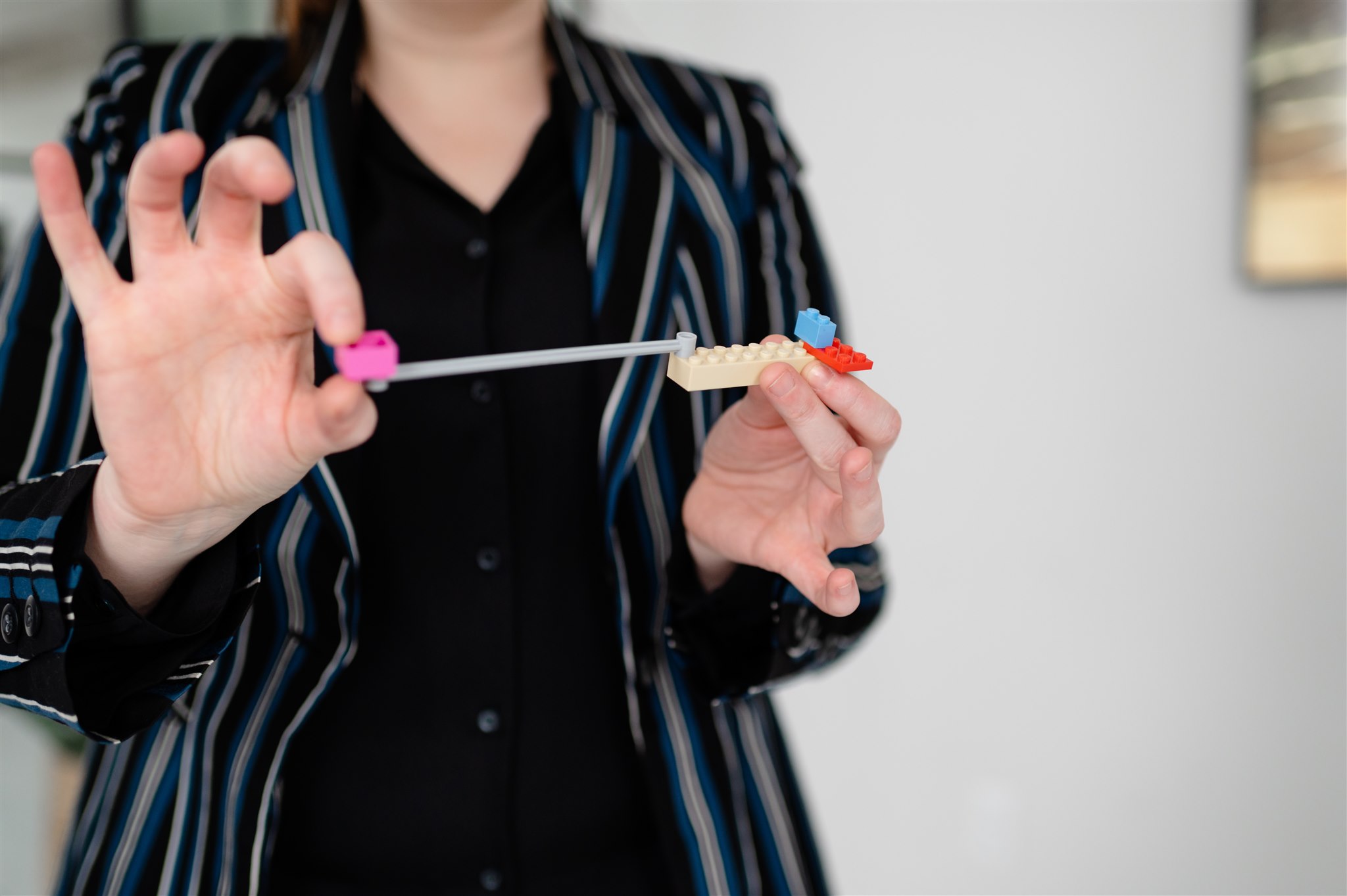 Close up of person's hands/torso holding LEGO model